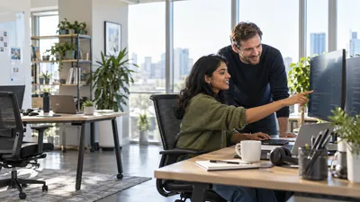 Software engineers collaborating on an application in a sunlit office
